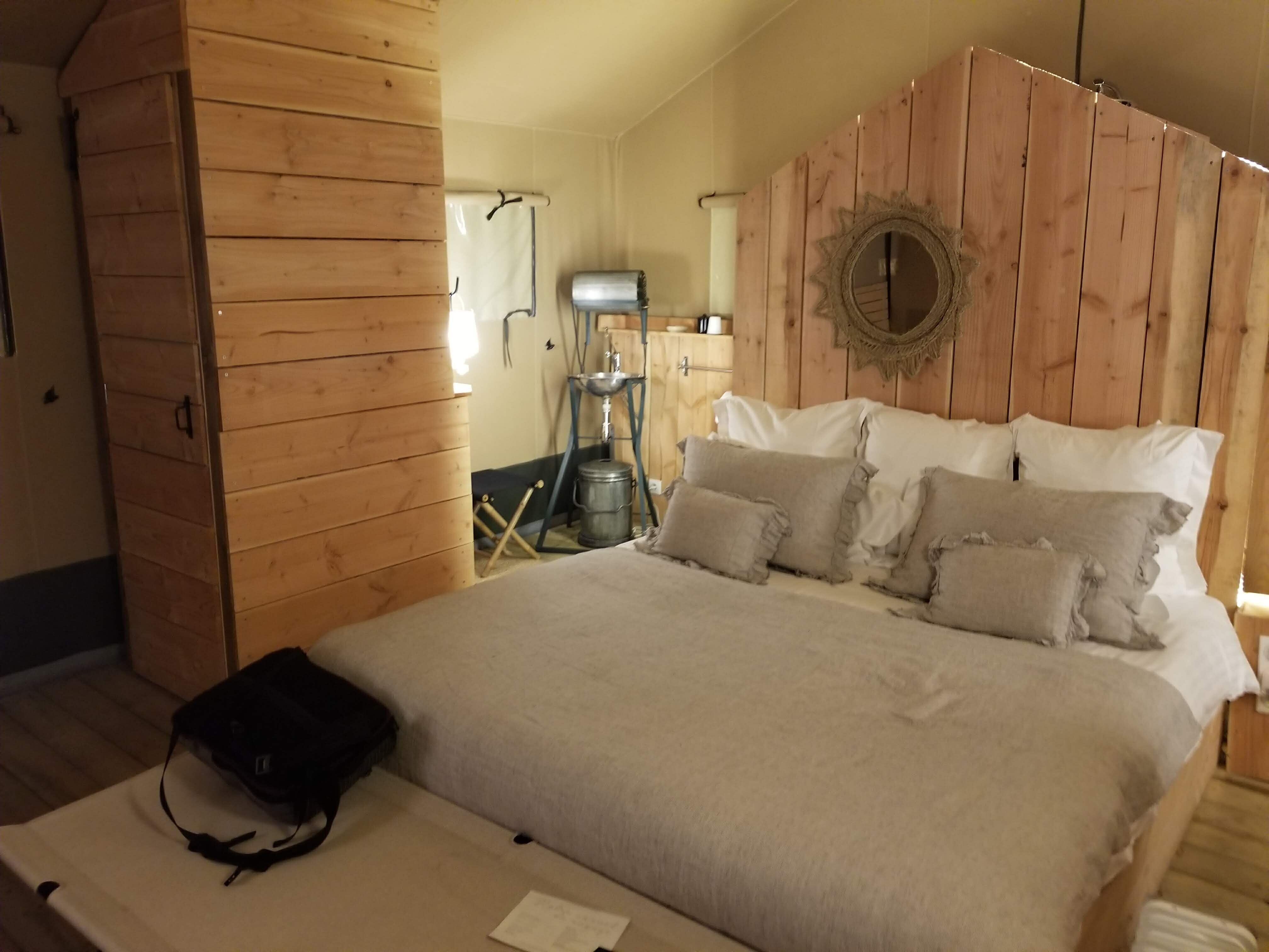 King-size bed in a rustic wood and canvas room.